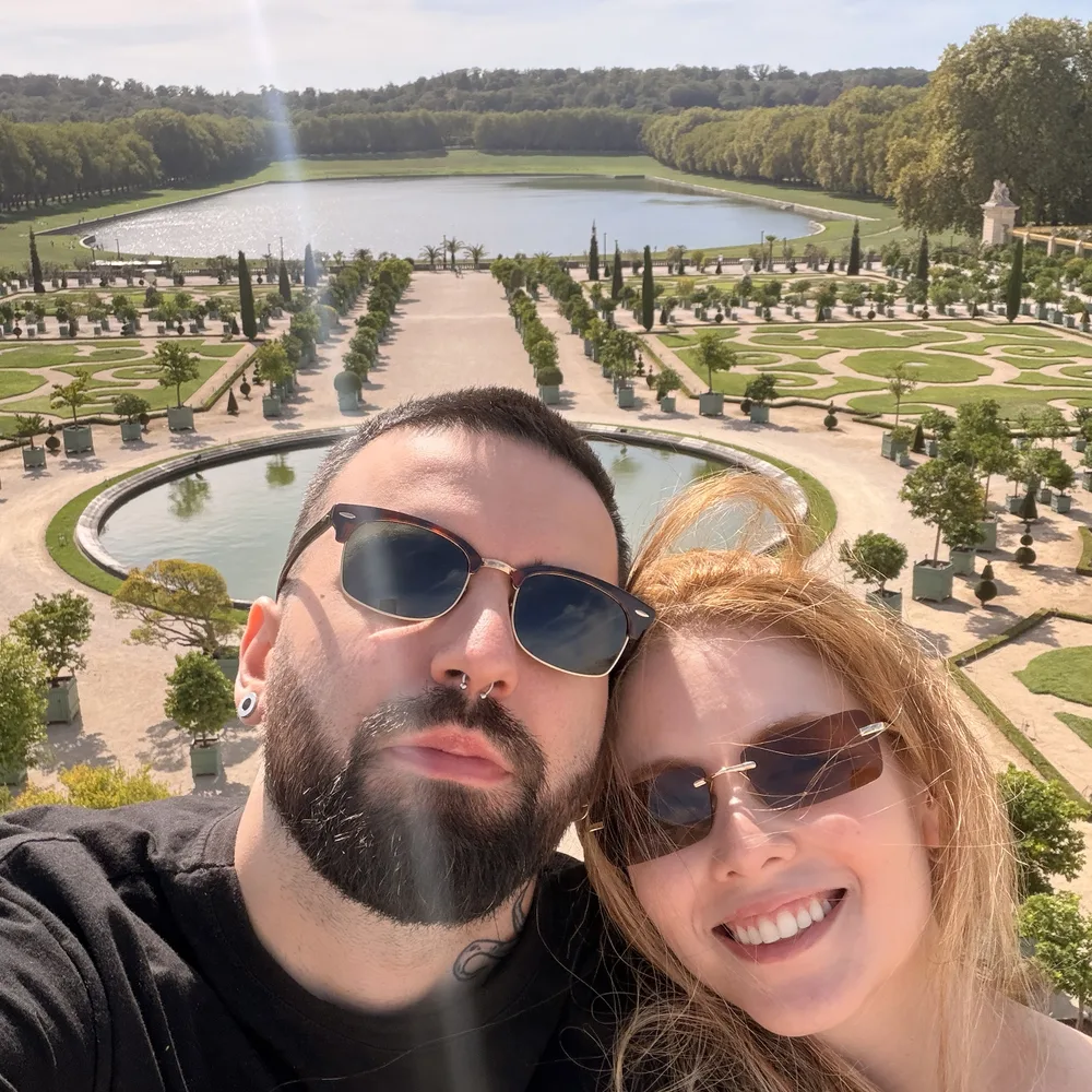 Selfie do casal sorrindo nos jardins de Versalhes